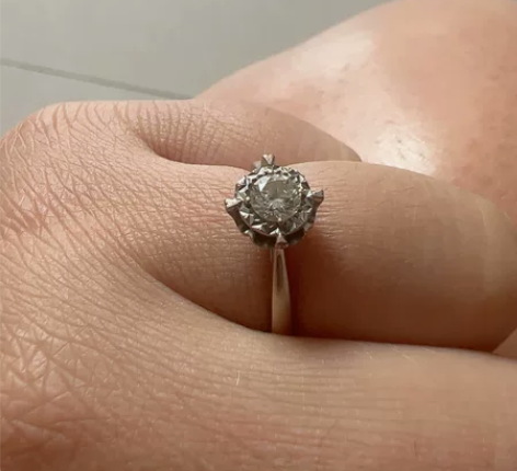 出一枚精致的钻石戒指，来自知名品牌，拥有优...