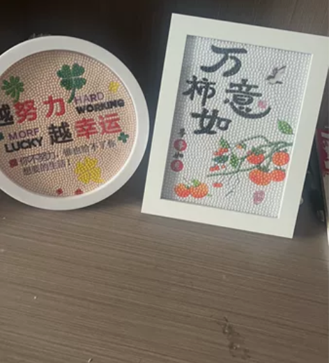 出多幅手工钻石画，采用白色背景搭配多彩花卉...