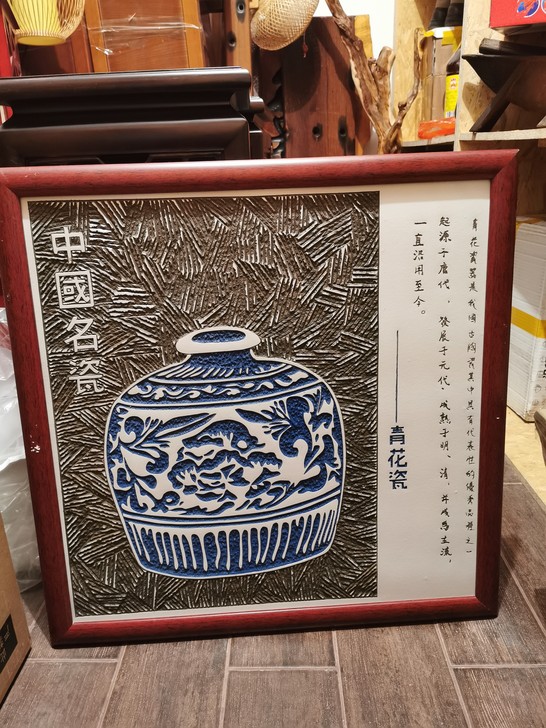 此为中国独有的瓷板雕刻画,雕刻一个青花瓷罐...